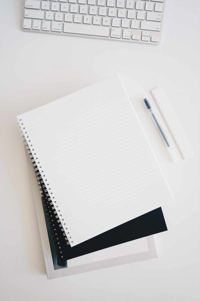 stack of notebooks and a pen